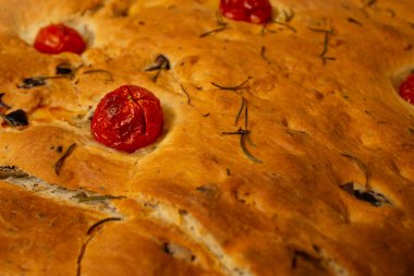 Fırında pişirilmiş, domatesli ve biberiyeli Focaccia ekmeği.