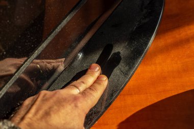 Erkek parmaklar tozlu bir televizyon standını parlak yüzeyiyle kirletiyor, yumuşak odaklı.