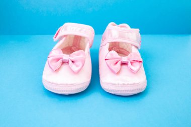 Bir çift yeni doğmuş pembe ayakkabı. Mavi arka planda ön manzara.,