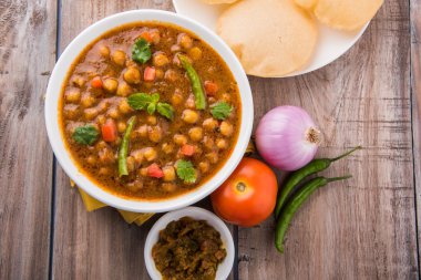 Baharatlı nohut Çola Masala veya Chana Masala veya kolesistektomi olarak da bilinen Kızarmış puri, turşu ve yeşil salata ile servis