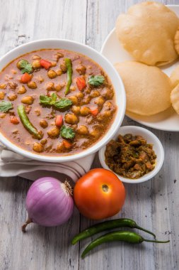 Baharatlı nohut Çola Masala veya Chana Masala veya kolesistektomi olarak da bilinen Kızarmış puri, turşu ve yeşil salata ile servis