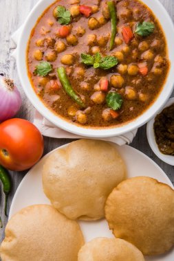Baharatlı nohut Çola Masala veya Chana Masala veya kolesistektomi olarak da bilinen Kızarmış puri, turşu ve yeşil salata ile servis