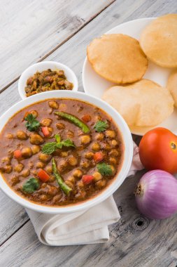 Baharatlı nohut Çola Masala veya Chana Masala veya kolesistektomi olarak da bilinen Kızarmış puri, turşu ve yeşil salata ile servis