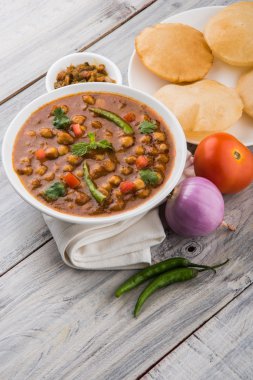 Baharatlı nohut Çola Masala veya Chana Masala veya kolesistektomi olarak da bilinen Kızarmış puri, turşu ve yeşil salata ile servis