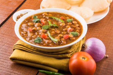 Baharatlı nohut Çola Masala veya Chana Masala veya kolesistektomi olarak da bilinen Kızarmış puri, turşu ve yeşil salata ile servis