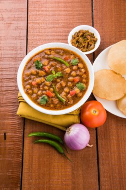 Baharatlı nohut Çola Masala veya Chana Masala veya kolesistektomi olarak da bilinen Kızarmış puri, turşu ve yeşil salata ile servis