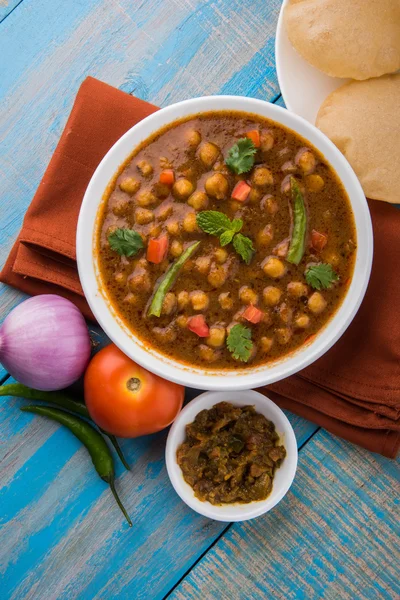 Garbanzos picantes también conocidos como Chola Masala o Chana Masala o Chole servido con puri frito, encurtido y ensalada verde — Foto de Stock