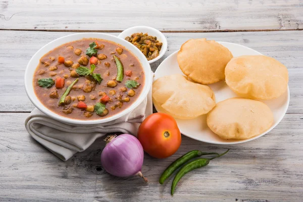 Garbanzos picantes también conocidos como Chola Masala o Chana Masala o Chole servido con puri frito, encurtido y ensalada verde — Foto de Stock
