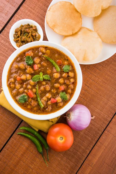 Baharatlı nohut Çola Masala veya Chana Masala veya kolesistektomi olarak da bilinen Kızarmış puri, turşu ve yeşil salata ile servis