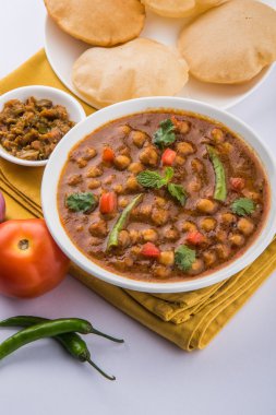 Baharatlı nohut Çola Masala veya Chana Masala veya kolesistektomi olarak da bilinen Kızarmış puri, turşu ve yeşil salata ile servis