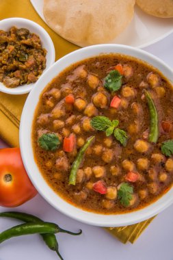 Baharatlı nohut Çola Masala veya Chana Masala veya kolesistektomi olarak da bilinen Kızarmış puri, turşu ve yeşil salata ile servis
