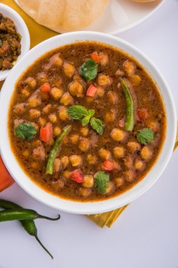 Baharatlı nohut Çola Masala veya Chana Masala veya kolesistektomi olarak da bilinen Kızarmış puri, turşu ve yeşil salata ile servis
