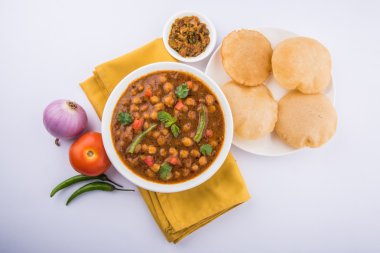 Baharatlı nohut Çola Masala veya Chana Masala veya kolesistektomi olarak da bilinen Kızarmış puri, turşu ve yeşil salata ile servis