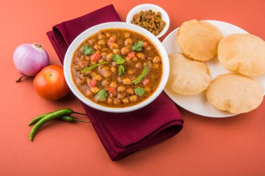 Baharatlı nohut Çola Masala veya Chana Masala veya kolesistektomi olarak da bilinen Kızarmış puri, turşu ve yeşil salata ile servis