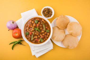 Baharatlı nohut Çola Masala veya Chana Masala veya kolesistektomi olarak da bilinen Kızarmış puri, turşu ve yeşil salata ile servis