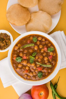 Baharatlı nohut Çola Masala veya Chana Masala veya kolesistektomi olarak da bilinen Kızarmış puri, turşu ve yeşil salata ile servis