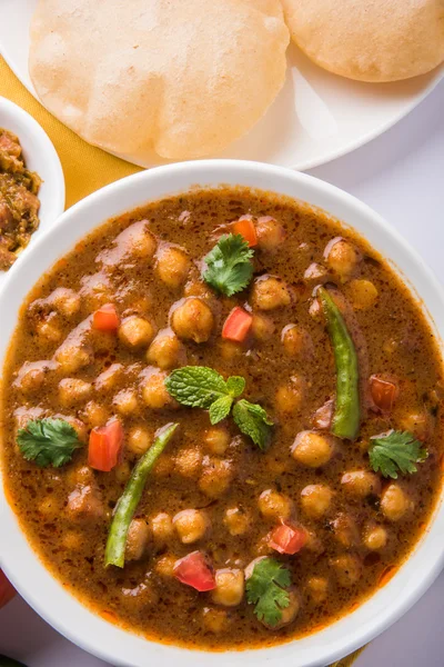 Kryddiga kikärtor kallas även Chola Masala eller Chana Masala eller Chole serveras med stekt puri, ättikslag och grönsallad — Stockfoto