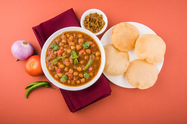 Spicy chick peas also known as Chola Masala or Chana Masala or Chole served with fried puri, pickle and green salad — Stock Photo, Image