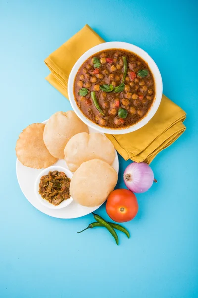 Ervilhas picantes também conhecidas como Chola Masala ou Chana Masala ou Chole servido com puri frito, picles e salada verde — Fotografia de Stock