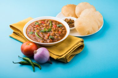 Baharatlı nohut Çola Masala veya Chana Masala veya kolesistektomi olarak da bilinen Kızarmış puri, turşu ve yeşil salata ile servis