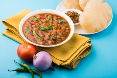Baharatlı nohut Çola Masala veya Chana Masala veya kolesistektomi olarak da bilinen Kızarmış puri, turşu ve yeşil salata ile servis