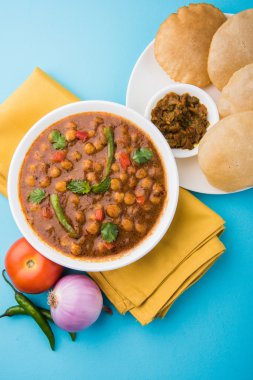 Baharatlı nohut Çola Masala veya Chana Masala veya kolesistektomi olarak da bilinen Kızarmış puri, turşu ve yeşil salata ile servis