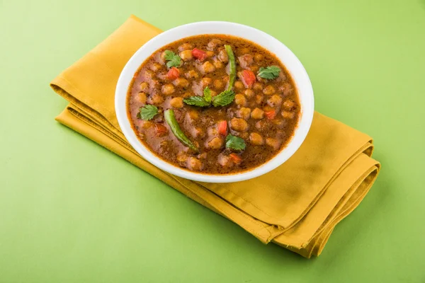indian dish spicy Chick Peas also known as Chola Masala or Chana Masala or Chole served in a white bowl, isolated