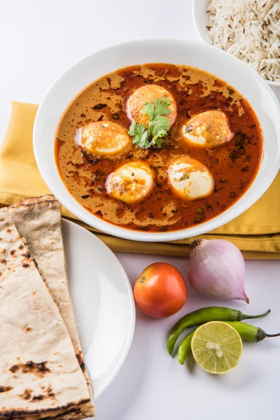 Curry de huevo con roti / chapati y arroz jeera, curry anda sabroso y picante con roti y arroz, curry de masala de huevo indio servido en tazón de cerámica con roti, ensalada y arroz jeera — Foto de Stock
