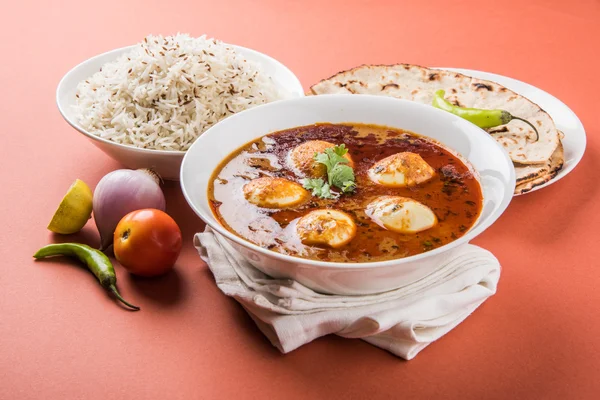 Curry de huevo con roti / chapati y arroz jeera, curry anda sabroso y picante con roti y arroz, curry de masala de huevo indio servido en tazón de cerámica con roti, ensalada y arroz jeera — Foto de Stock