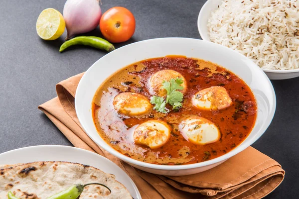 Curry d'oeufs avec roti / chapati et riz jeera, curry savoureux et épicé et roti et riz, oeuf indien masala curry servi dans un bol en céramique avec roti, salade et riz jeera — Photo