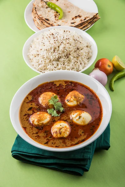 Curry de huevo con roti / chapati y arroz jeera, curry anda sabroso y picante con roti y arroz, curry de masala de huevo indio servido en tazón de cerámica con roti, ensalada y arroz jeera —  Fotos de Stock