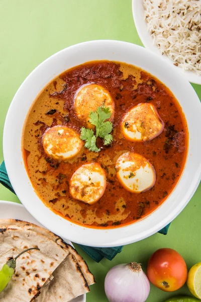 Egg curry with roti/chapati and jeera rice, tasty and spicy anda curry with roti and rice, indian egg masala curry served in ceramic bowl with roti, salad and jeera rice — Stock Photo, Image