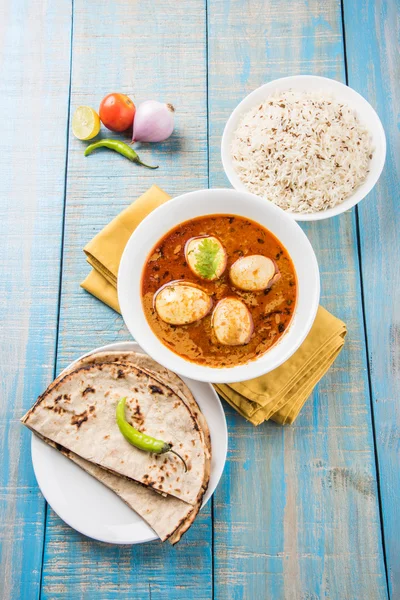 Curry de huevo con roti / chapati y arroz jeera, curry anda sabroso y picante con roti y arroz, curry de masala de huevo indio servido en tazón de cerámica con roti, ensalada y arroz jeera — Foto de Stock