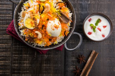 Basmati rice slowly cooked with Masala roasted egg and spices served in kadhai or kadai with yogurt dip, selective focus, egg biryani or anda rice or egg rice clipart