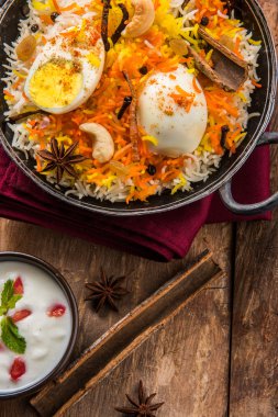 Basmati rice slowly cooked with Masala roasted egg and spices served in kadhai or kadai with yogurt dip, selective focus, egg biryani or anda rice or egg rice clipart