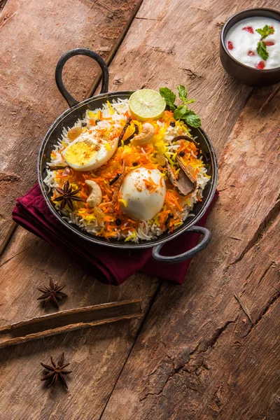 Riso Basmati cotto lentamente con uova arrosto Masala e spezie servite in kadhai o kadai con salsa allo yogurt, fuoco selettivo, biryani all'uovo o riso anda o riso all'uovo — Foto Stock