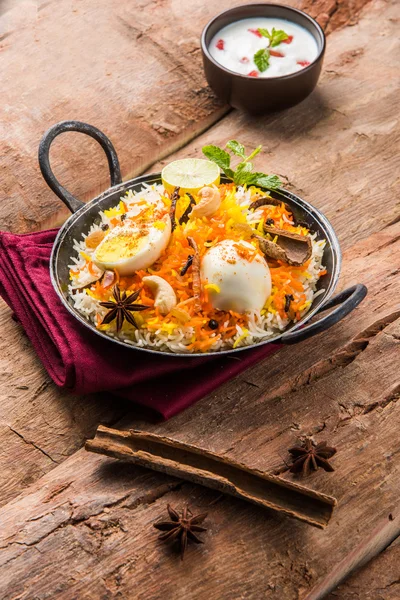 Riso Basmati cotto lentamente con uova arrosto Masala e spezie servite in kadhai o kadai con salsa allo yogurt, fuoco selettivo, biryani all'uovo o riso anda o riso all'uovo — Foto Stock