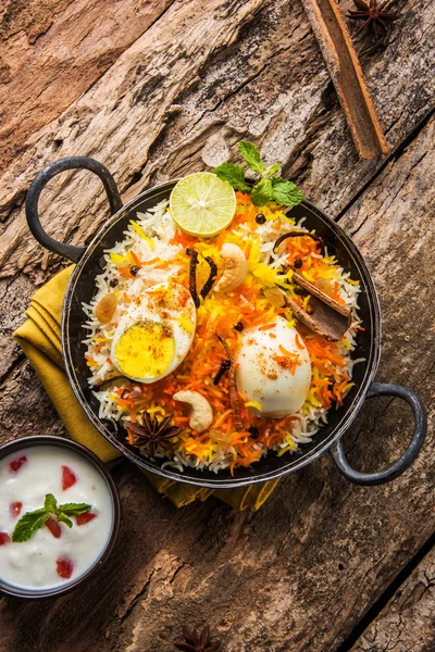 Riso Basmati cotto lentamente con uova arrosto Masala e spezie servite in kadhai o kadai con salsa allo yogurt, fuoco selettivo, biryani all'uovo o riso anda o riso all'uovo — Foto Stock