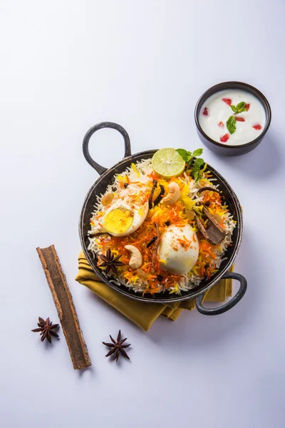 Arroz Basmati cozido lentamente com ovo assado Masala e especiarias servidas em kadhai ou kadai com molho de iogurte, foco seletivo, biryani ovo ou arroz anda ou arroz ovo — Fotografia de Stock