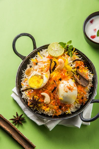 Riso Basmati cotto lentamente con uova arrosto Masala e spezie servite in kadhai o kadai con salsa allo yogurt, fuoco selettivo, biryani all'uovo o riso anda o riso all'uovo — Foto Stock