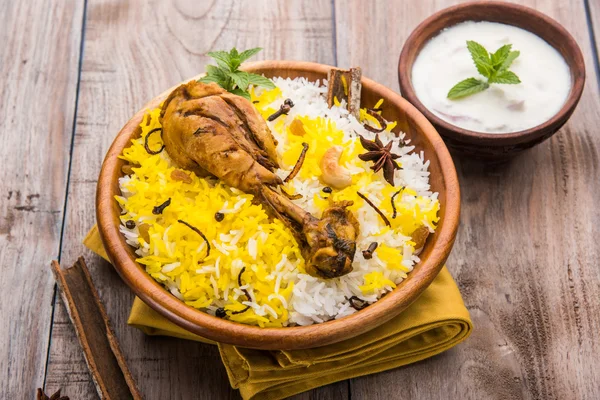 Chicken Biryani with yogurt dip on beautiful moody background, selective focus — Stock Photo, Image