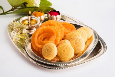 Güzel dekore Pooja Thali diwali kutlama veya ibadet için , Hint tatlılar, gümüş lamba, çiçek, huldi veya zerdeçal tozu ve gümüş süslenmiş tabakta kumkum sahip