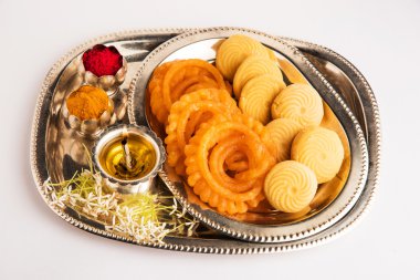 Güzel dekore Pooja Thali diwali kutlama veya ibadet için , Hint tatlılar, gümüş lamba, çiçek, huldi veya zerdeçal tozu ve gümüş süslenmiş tabakta kumkum sahip