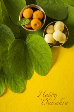 mutlu dussehra veya dussera tebrik kartı, hint festivali dussehra, gümüş kase geleneksel hint tatlılar pedha ile altın yaprak gösteren