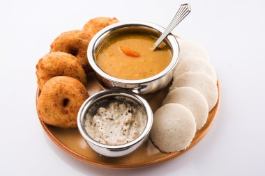 Sambar ile Sambar Vada & Idli, hindistan cevizi chutney ve kırmızı domates chutney, Hint Çanak toprak plaka ve beyaz arka plan üzerinde kase servis, ön görünüm, beyaz arka plan üzerinde izole
