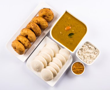 Sambar Vada & Idli sambar, hindistan cevizi chutney ve kırmızı domates chutney ile, Hint Çanak beyaz plaka ve beyaz arka plan üzerinde kase servis