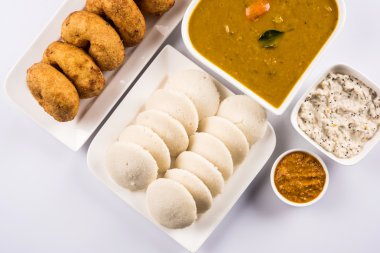 Sambar Vada & Idli sambar, hindistan cevizi chutney ve kırmızı domates chutney ile, Hint Çanak beyaz plaka ve beyaz arka plan üzerinde kase servis