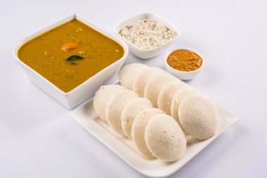 beyaz arka plan üzerinde beyaz seramik kare plaka ve kase geleneksel güney hint gıda, idli veya idly sambar ve beyaz hindistan cevizi chutney ve kırmızı chutney ile, ön görünümü beyaz arka plan üzerinde izole