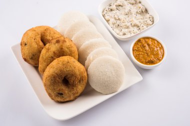 Sambar Vada & Idli sambar, hindistan cevizi chutney ve kırmızı domates chutney ile, Hint Çanak beyaz plaka ve beyaz arka plan üzerinde kase servis