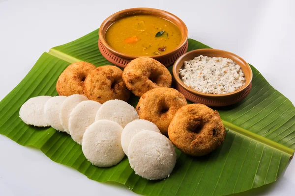 Sambar Vada – Idli 与桑巴， 椰子甜甜圈和红色番茄酱在土锅， 服务在绿色香蕉叶在白色背景 — 图库照片